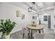 Dining area with an oval table, modern light fixture, and view into the kitchen and stainless steel refrigerator at 330 Pineapple St, Tarpon Springs, FL 34689