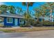 A charming exterior view of a blue home with tropical plants and a sidewalk at 330 Pineapple St, Tarpon Springs, FL 34689
