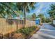 View of fenced property with blue building and palm trees at 330 Pineapple St, Tarpon Springs, FL 34689
