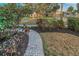 Inviting front yard with a paved walkway and lush garden beds leading to a charming yellow home at 330 Pineapple St, Tarpon Springs, FL 34689