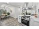 Bright, open-concept kitchen with stainless steel appliances, white cabinets, and a view into the dining area at 330 Pineapple St, Tarpon Springs, FL 34689