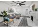 Bright living room featuring modern decor, fireplace, an oversized ceiling fan, and gray wood flooring at 330 Pineapple St, Tarpon Springs, FL 34689