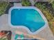 Aerial perspective of an outdoor pool featuring clear blue water, steps, patio, and two blue chairs at 330 Pineapple St, Tarpon Springs, FL 34689