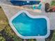 Aerial view of private backyard pool with surrounding brick pavers, landscaping, and patio furniture at 330 Pineapple St, Tarpon Springs, FL 34689