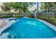 A backyard pool with clear blue water and surrounding privacy fence and landscaping at 330 Pineapple St, Tarpon Springs, FL 34689