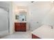 Bright bathroom featuring double vanity, white tile flooring, and a glass-enclosed shower at 3429 Heards Ferry Dr, Tampa, FL 33618