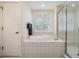 Relaxing bathroom retreat with a soaking tub, separate shower, and natural light from plantation shutters at 3429 Heards Ferry Dr, Tampa, FL 33618