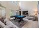 Spacious game room featuring a pool table, comfortable seating, and sliding doors to the patio at 3429 Heards Ferry Dr, Tampa, FL 33618