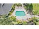 Aerial view of a community pool surrounded by a brick patio, lounge chairs, and lush landscaping at 3429 Heards Ferry Dr, Tampa, FL 33618