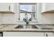 Stylish kitchen sink area with a modern faucet, white cabinets, and natural light at 3838 29Th N St, St Petersburg, FL 33714