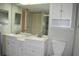 This bathroom features a double sink vanity with modern fixtures, white cabinets, and a mirrored wall at 3861 Sailmaker Ln # 3861, Holiday, FL 34691
