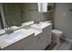 Bright bathroom featuring a double sink vanity, white cabinets, modern fixtures, and wood look flooring at 3861 Sailmaker Ln # 3861, Holiday, FL 34691