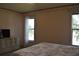 Bedroom with a TV on a dresser, two windows, and floral wallpaper border at 3861 Sailmaker Ln # 3861, Holiday, FL 34691