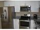 Modern kitchen featuring stainless steel appliances, granite countertops, and white cabinetry at 3861 Sailmaker Ln # 3861, Holiday, FL 34691