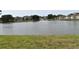 Picturesque lake view with a fountain in the center, surrounded by well-maintained grassy area and houses at 3861 Sailmaker Ln # 3861, Holiday, FL 34691