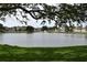 Scenic lake view featuring a fountain, lush greenery, and well-maintained residential buildings at 3861 Sailmaker Ln # 3861, Holiday, FL 34691