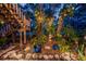 Lush backyard featuring landscape lighting, seating area and a wooden stairway at 420 Hanby St, Crystal Beach, FL 34681