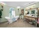 Light and airy bathroom featuring a clawfoot tub and ornate vanity with chandelier at 420 Hanby St, Crystal Beach, FL 34681