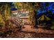 Charming home with colorful stairs, lush landscaping, outdoor lighting, and comfortable seating amidst mature trees at 420 Hanby St, Crystal Beach, FL 34681
