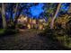 Evening view of home exterior with an outdoor deck, mature landscaping, and unique elevation at 420 Hanby St, Crystal Beach, FL 34681