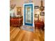 Elegant foyer with wood floors, a blue decorative front door, and antique furniture showcasing a welcoming entrance at 420 Hanby St, Crystal Beach, FL 34681