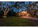 Inviting home exterior with a spacious yard and unique architectural design set against a backdrop of mature trees at 420 Hanby St, Crystal Beach, FL 34681