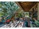Inviting outdoor patio with colorful tile flooring, stairs, seating, and lush landscaping creates a tranquil space at 420 Hanby St, Crystal Beach, FL 34681