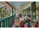 Spacious screened porch with wicker seating, floral rug, and decor offers a cozy outdoor living space at 420 Hanby St, Crystal Beach, FL 34681