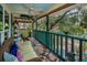 Relaxing screened porch featuring comfortable wicker seating, floral rug, ceiling fan, and views of nature at 420 Hanby St, Crystal Beach, FL 34681