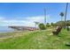 Beautiful waterfront view of a charming wooden dock with a bench and lush greenery at 420 Hanby St, Crystal Beach, FL 34681