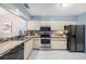 Functional kitchen design featuring stainless steel appliances, tiled countertops, and white cabinetry at 4270 Boston Cir, New Port Richey, FL 34653