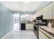 Bright kitchen featuring tiled countertops, and views of the lanai through a serving hatch at 4270 Boston Cir, New Port Richey, FL 34653