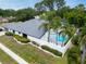A white-walled home and pool are surrounded by palm trees, manicured shrubs and a sidewalk at 430 Hickory Nut, Oldsmar, FL 34677