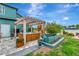 Backyard with a hot tub under a pergola, beautiful landscaping, and ample space for outdoor enjoyment at 5103 Rushbrook Rd, Land O Lakes, FL 34638