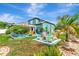 Backyard featuring a hot tub, fire pit, tropical landscaping, and white picket fence, creating a tranquil outdoor retreat at 5103 Rushbrook Rd, Land O Lakes, FL 34638