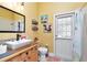 Bathroom with yellow walls, wood vanity, and walk-out access to the backyard at 5103 Rushbrook Rd, Land O Lakes, FL 34638