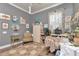 A gray bedroom styled as an office featuring a ceiling fan, hardwood floors, and a window with floral curtains at 5103 Rushbrook Rd, Land O Lakes, FL 34638