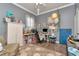 Cozy bedroom designed as an office with hardwood floors, ceiling fan, and a window with sheer floral curtains at 5103 Rushbrook Rd, Land O Lakes, FL 34638