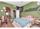 Green bedroom with hardwood floors, bed, and an open doorway to another room at 5103 Rushbrook Rd, Land O Lakes, FL 34638
