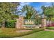 Community entrance sign for Pine Glen, with stone pillars and lush landscaping at 5103 Rushbrook Rd, Land O Lakes, FL 34638