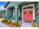 Inviting front porch features a red door, plants, seating, and decorative elements at 5103 Rushbrook Rd, Land O Lakes, FL 34638