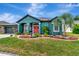 Beautiful home featuring teal paint, red front door, manicured lawn and a palm tree at 5103 Rushbrook Rd, Land O Lakes, FL 34638