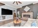 Inviting living room featuring a stone fireplace, entertainment center, and hardwood flooring at 5103 Rushbrook Rd, Land O Lakes, FL 34638
