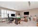 Large home office featuring two desks, hardwood floors, and multiple windows with shutters at 5103 Rushbrook Rd, Land O Lakes, FL 34638