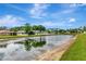 Water view of a pond with houses in the background with a white fence around the backyard at 5103 Rushbrook Rd, Land O Lakes, FL 34638