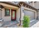 Home exterior featuring a covered entry, red door, two-car garage, and beautifully landscaped front yard at 5103 San Martino Dr, Wesley Chapel, FL 33543