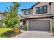 Charming two-story home featuring a brick driveway, attached two-car garage, and beautifully landscaped front yard at 5103 San Martino Dr, Wesley Chapel, FL 33543