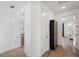 Bright hallway with hardwood flooring, white walls, and access to a powder room at 5103 San Martino Dr, Wesley Chapel, FL 33543
