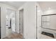 Bright hallway with hardwood flooring and white doors leading to the bathrooms at 5103 San Martino Dr, Wesley Chapel, FL 33543