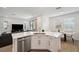 Bright kitchen island with stainless steel appliances and quartz countertops overlooking the living room and dining area at 5103 San Martino Dr, Wesley Chapel, FL 33543